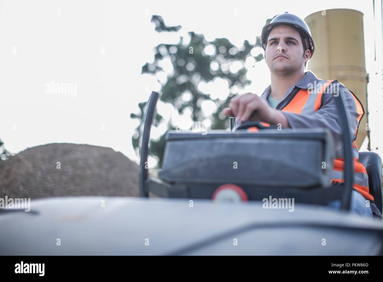 Junge männliche Dampfwalze Fahrer auf Baustelle Stockfoto