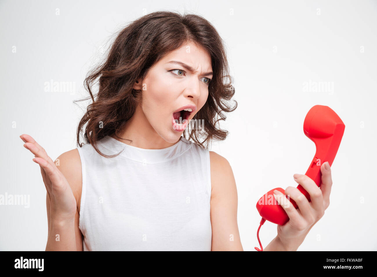 Böse Frau schreiend auf Telefon Rohr isoliert auf weißem Hintergrund Stockfoto