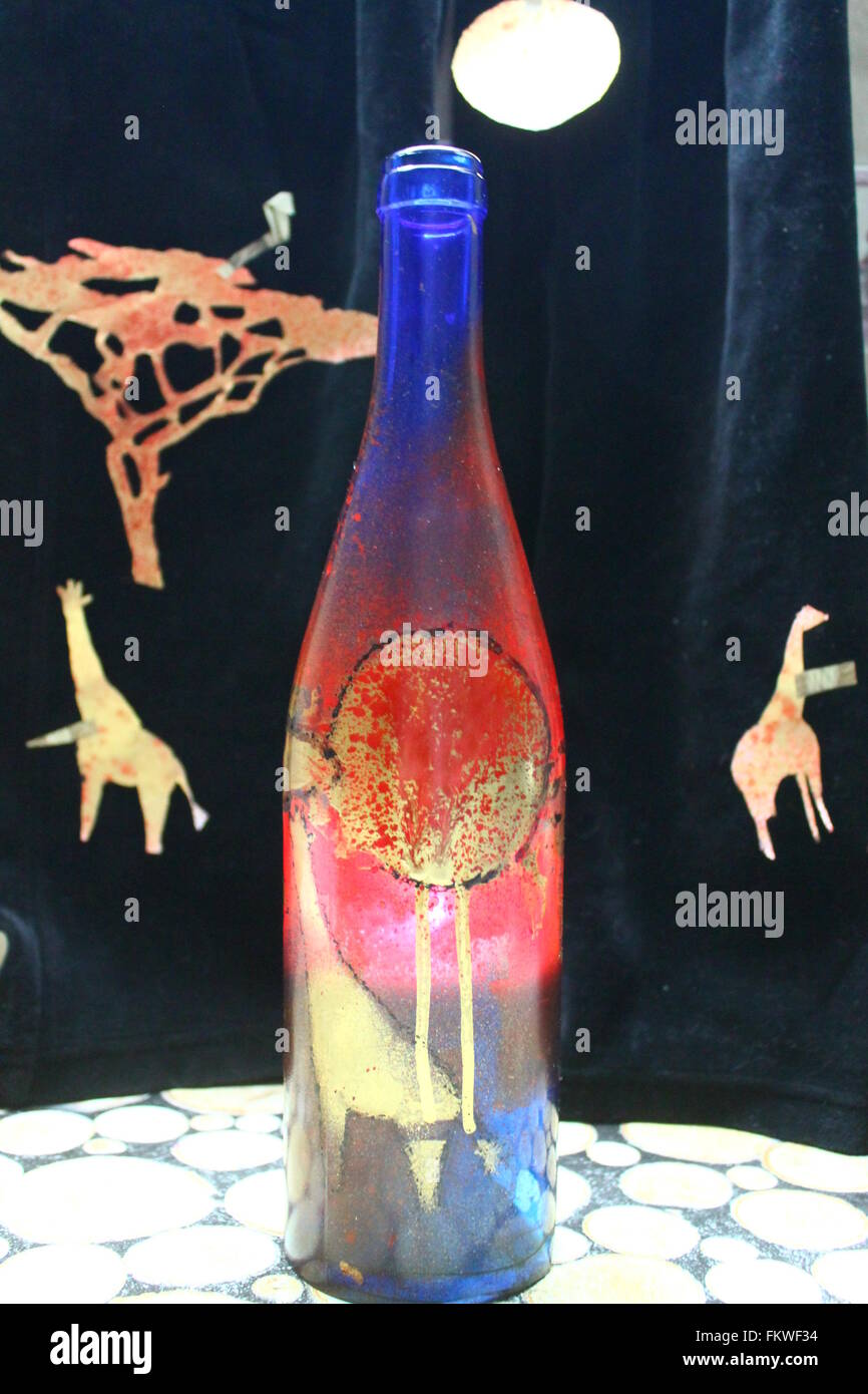 blaue Flasche unter Wine mit bunten afrikanischen Savanne wie Lampenschirm mit Kerze brennen innen zeichnen Stockfoto