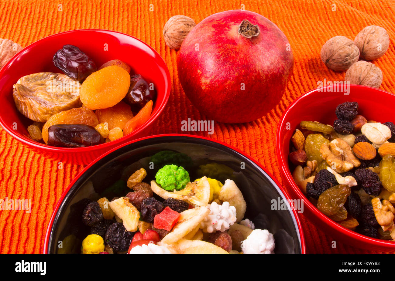 verschiedene getrocknete und frische Früchte auf dem Textil orange Hintergrund Stockfoto