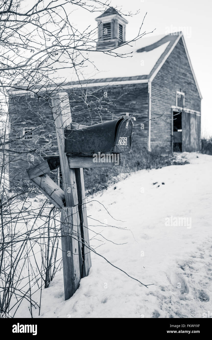 Eine alte, ländliche Postfach vor einer alten New England Scheune in schwarz und weiß mit blauen Toner abgenutzt. Stockfoto