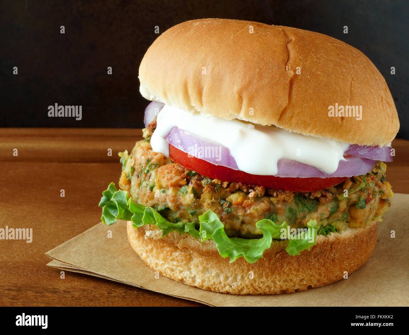 Warmen Falafel-Burger mit Salat, Tomaten und roten Zwiebeln mit Tzatziki sauce Stockfoto