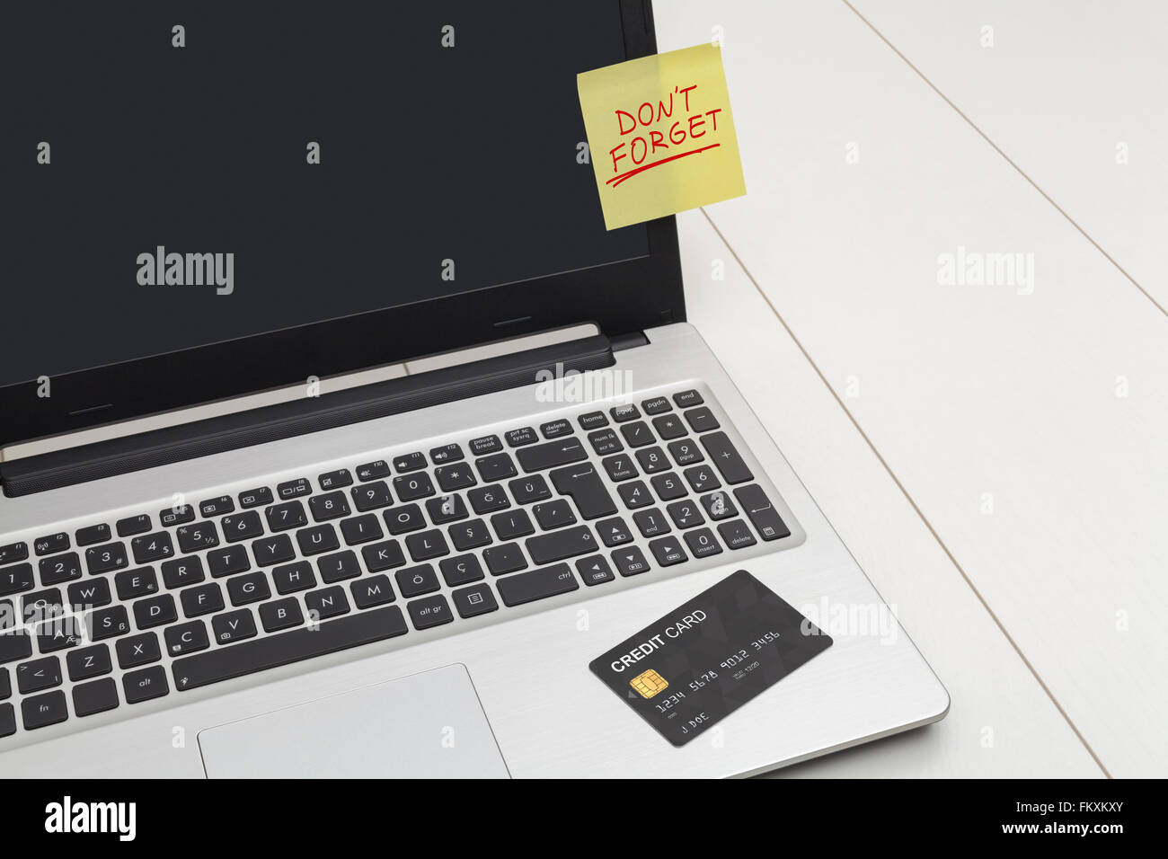 Kreditkarte, gelber Aufkleber mit Hinweis auf Laptop Vergiss nicht Stockfoto