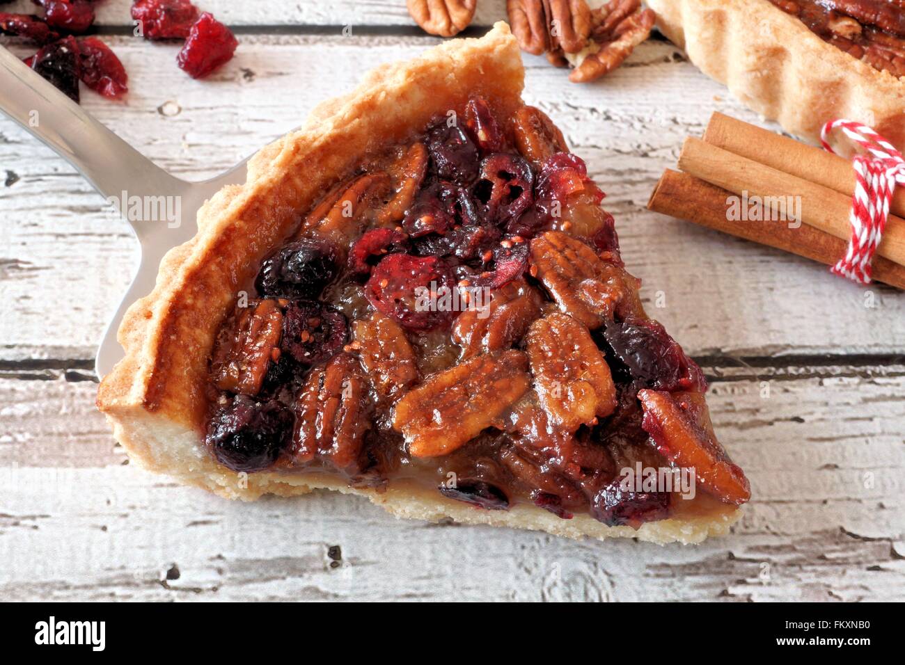 Stück vom süßen Pecan und Cranberry Torte auf Server mit alten Holz-Hintergrund Stockfoto