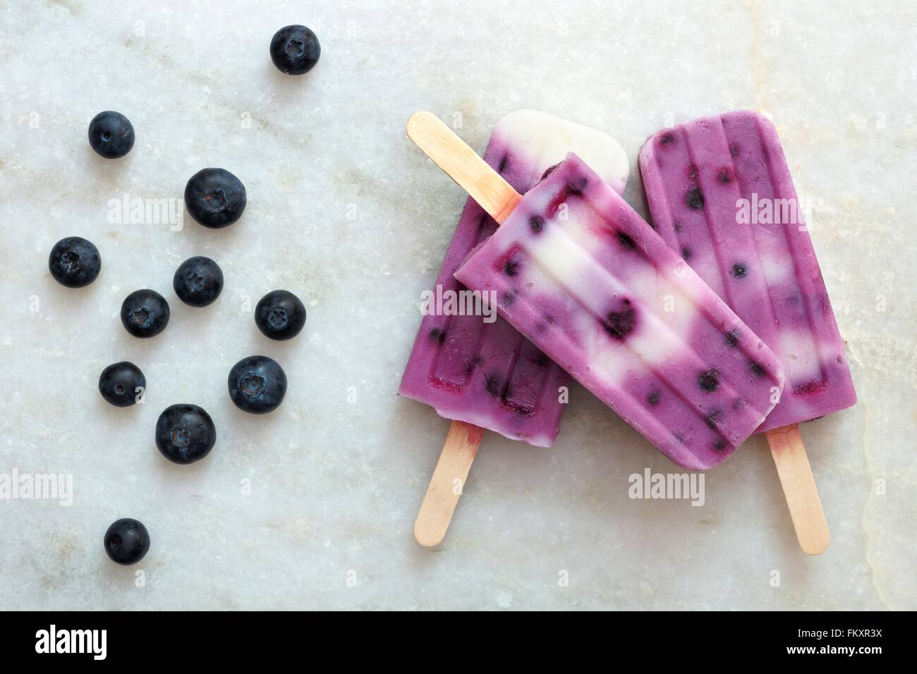 Heidelbeer-Vanille-Eis erscheint in einem Cluster auf einem weißen Marmor-Hintergrund Stockfoto