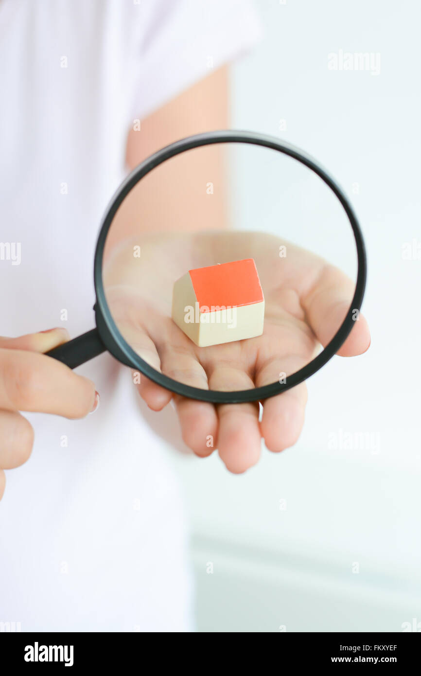Spielzeug-Haus unter der Lupe in der Hand der Frau, was darauf ...