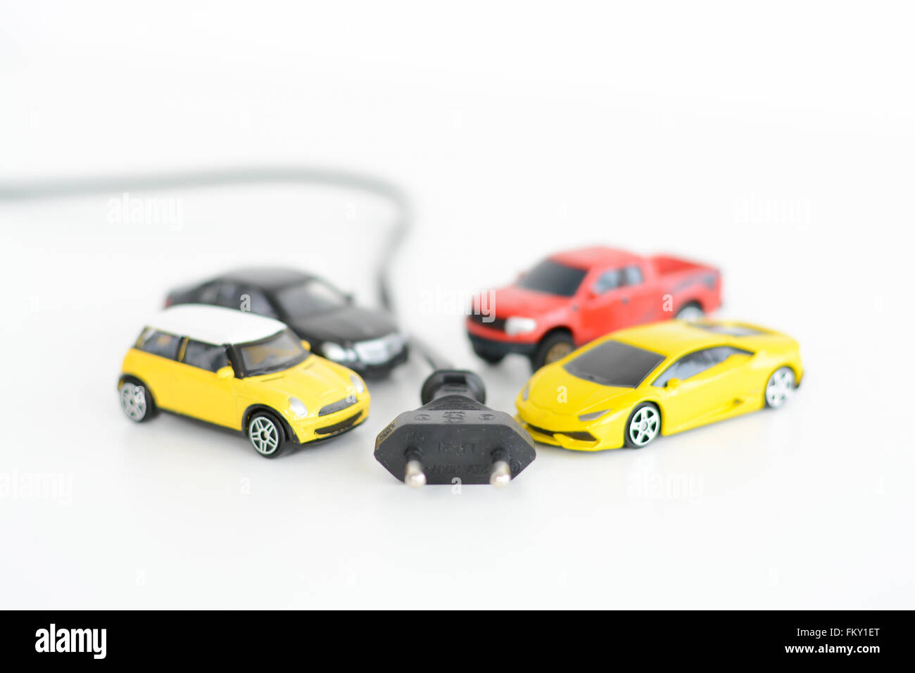 Elektroautos-Konzept mit vielen Spielzeug-Fahrzeuge auf weißem Hintergrund Stockfoto