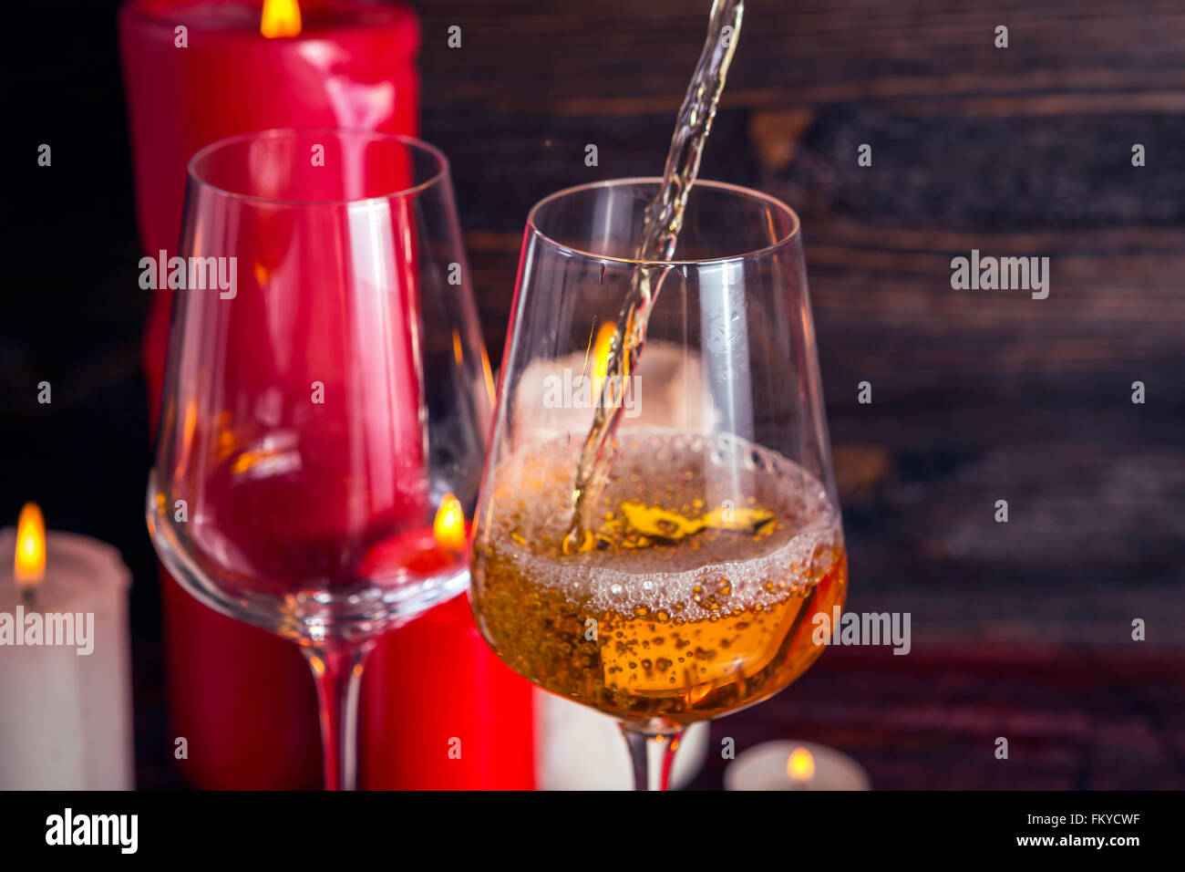 Zwei Gläser Wein und Kerzen auf dem dunklen Holz Hintergrund Stockfoto