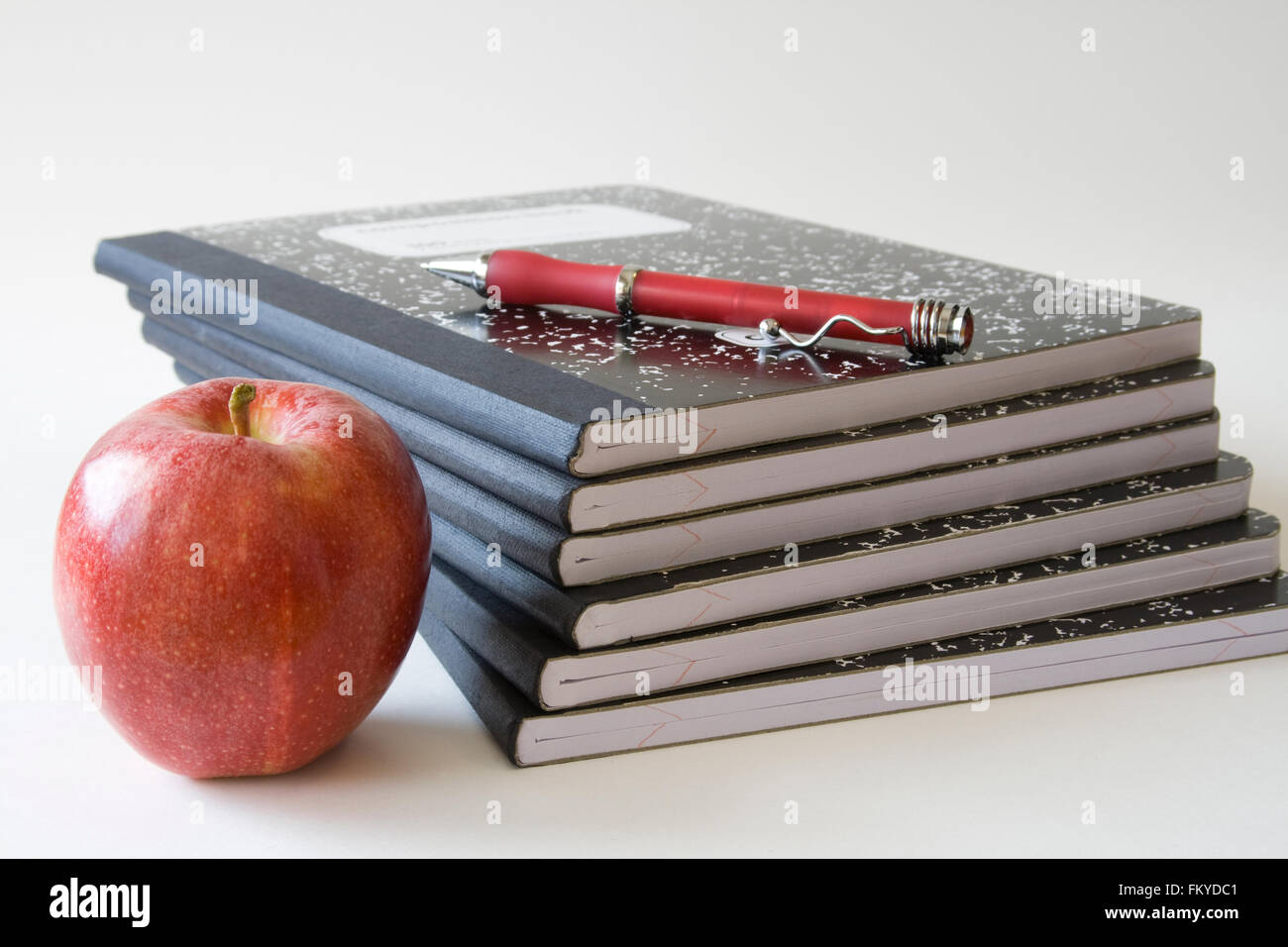 Schwarze Schule Notebooks mit Pen & apple Stockfoto