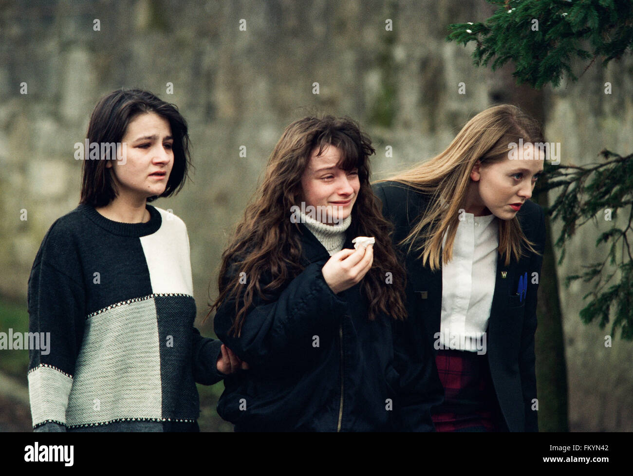 Drei junge Mädchen, Weinen, außerhalb Dunblane Primary School, Schottland, kurz nach der Schießerei auf dem Gelände. Das Massaker von Dunblane Schule war eines der tödlichsten Massenmorde in der britischen Geschichte, als Amokläufer Thomas Hamilton sechzehn Kinder und ein Lehrer in der Dunblane Primary School in der Nähe von Stirling, Schottland am 13. März 1996, vor sich selbst zu töten getötet. Als Folge der Morde wurden zwei neue Feuerwaffen Akten übergeben, wodurch effektiv Privateigentum an Handfeuerwaffen in Großbritannien verboten. Stockfoto