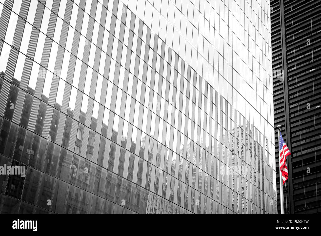 Amerikanische Flagge vor einem schwarzen und weißen Gebäude Glaswand, New York, USA. Stockfoto