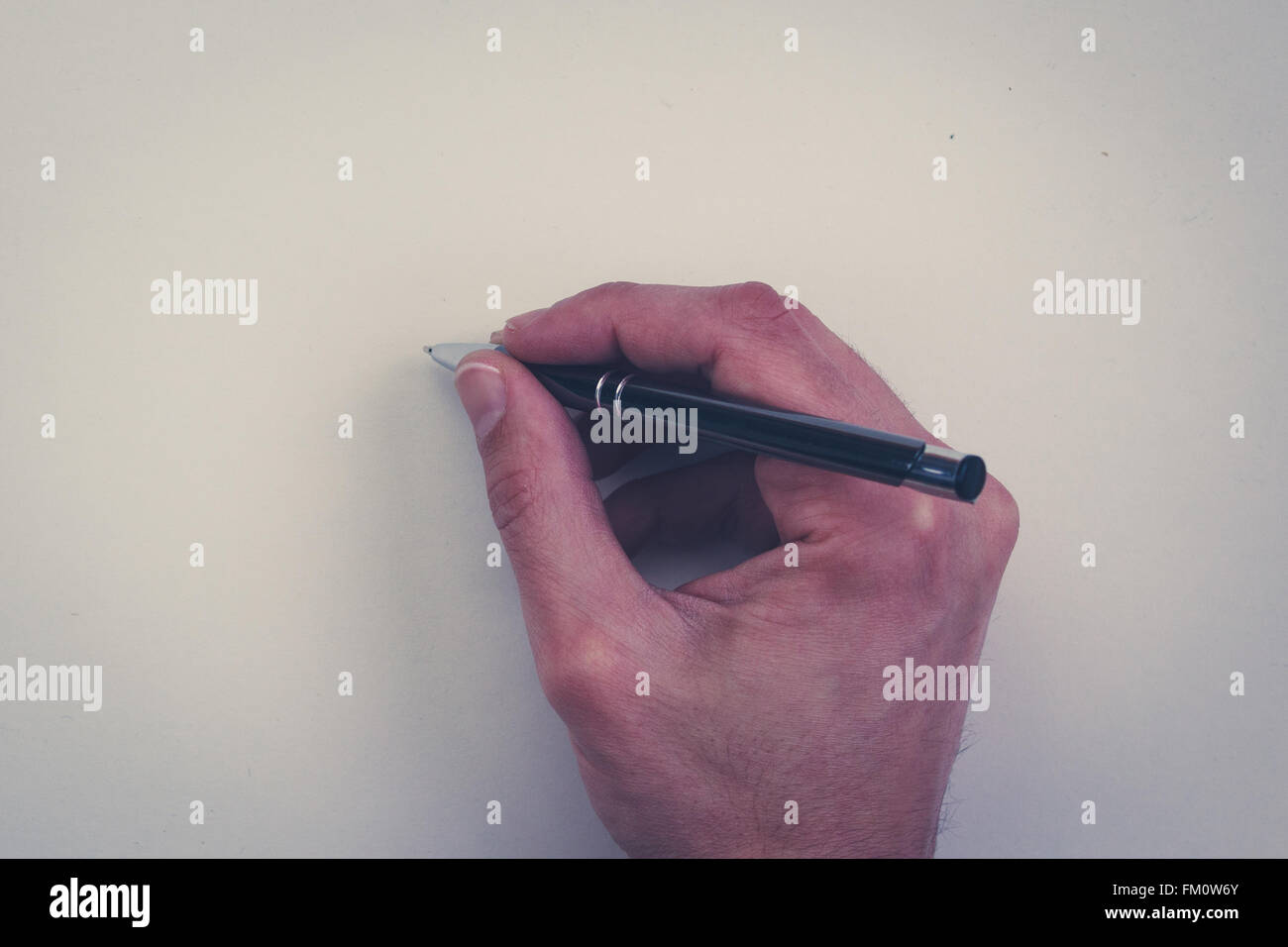 Hand mit Stift isoliert auf weißem Hintergrund - Hand mit Bleistift auf weißem Papier Stockfoto