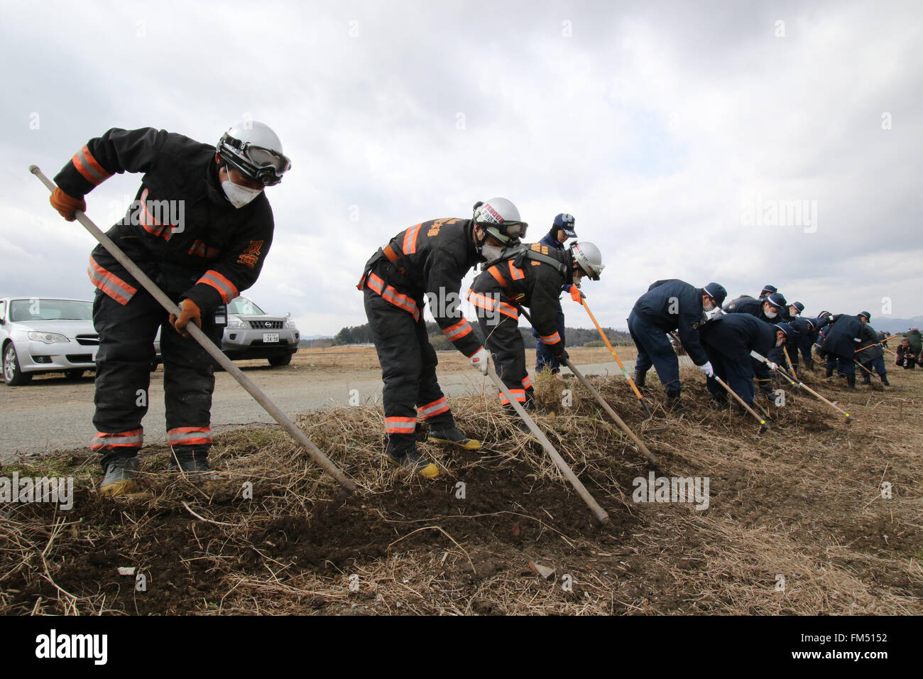 Tokio, Japan. 11. März 2016.  Polizisten suchen nach Überresten der fehlenden Tsunami-Opfer auf den Bereich durch den Tsunami am Namie in der Präfektur Fukushima in der Nähe von verkrüppelten TEPCO Kernkraftwerks am Freitag, 11. März 2016 zum fünften Jahrestag der Great East Japan Erdbeben und Tsunami zerstört. © Yoshio Tsunoda/AFLO/Alamy Live-Nachrichten Stockfoto