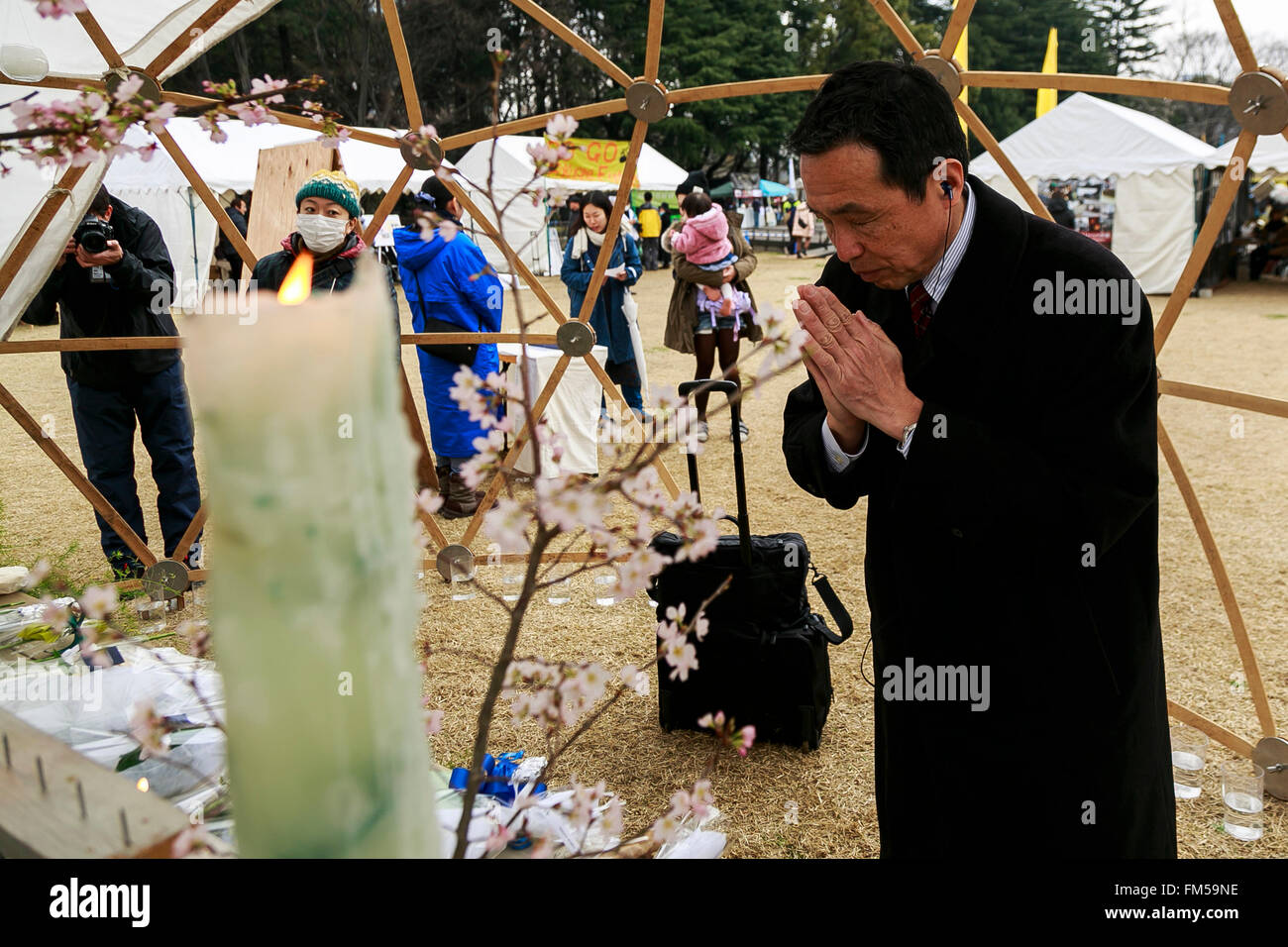 Tokio, Japan. 11. März 2016. Tokio, Japan. 11. März 2016. Ein Mann betet anlässlich des fünften Jahrestages der Great East Japan Erdbeben und Tsunami-Katastrophe in den Frieden auf Erden Gedenkfeier im Hibiya-Park am 11. März 2016, Tokio, Japan. Fast 19.000 Menschen starben durch das Erdbeben der Stärke 9,0 und der nachfolgende Tsunami, die Nordostküste Japans vor 5 Jahren getroffen. Fünf Jahre nach dem Ereignis sind einige 174.000 Überlebende noch in Notunterkünften. © Aflo Co. Ltd./Alamy Live-Nachrichten Stockfoto