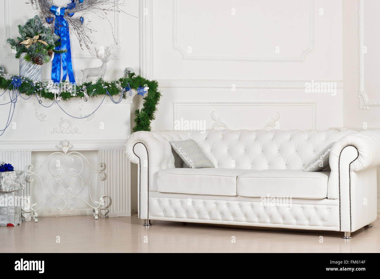 Weißes Ledersofa in Weihnachtsschmuck. Studio Innenräume in Weihnachtsstil und leuchtenden Farben Stockfoto