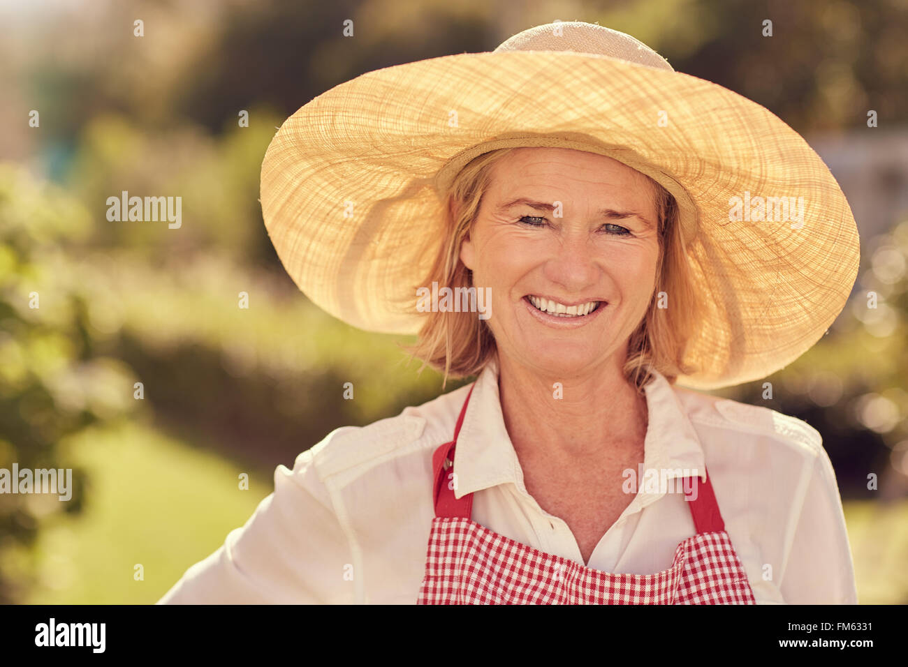 Porträt einer lächelnden senior Frau im Strohhut im freien Stockfoto