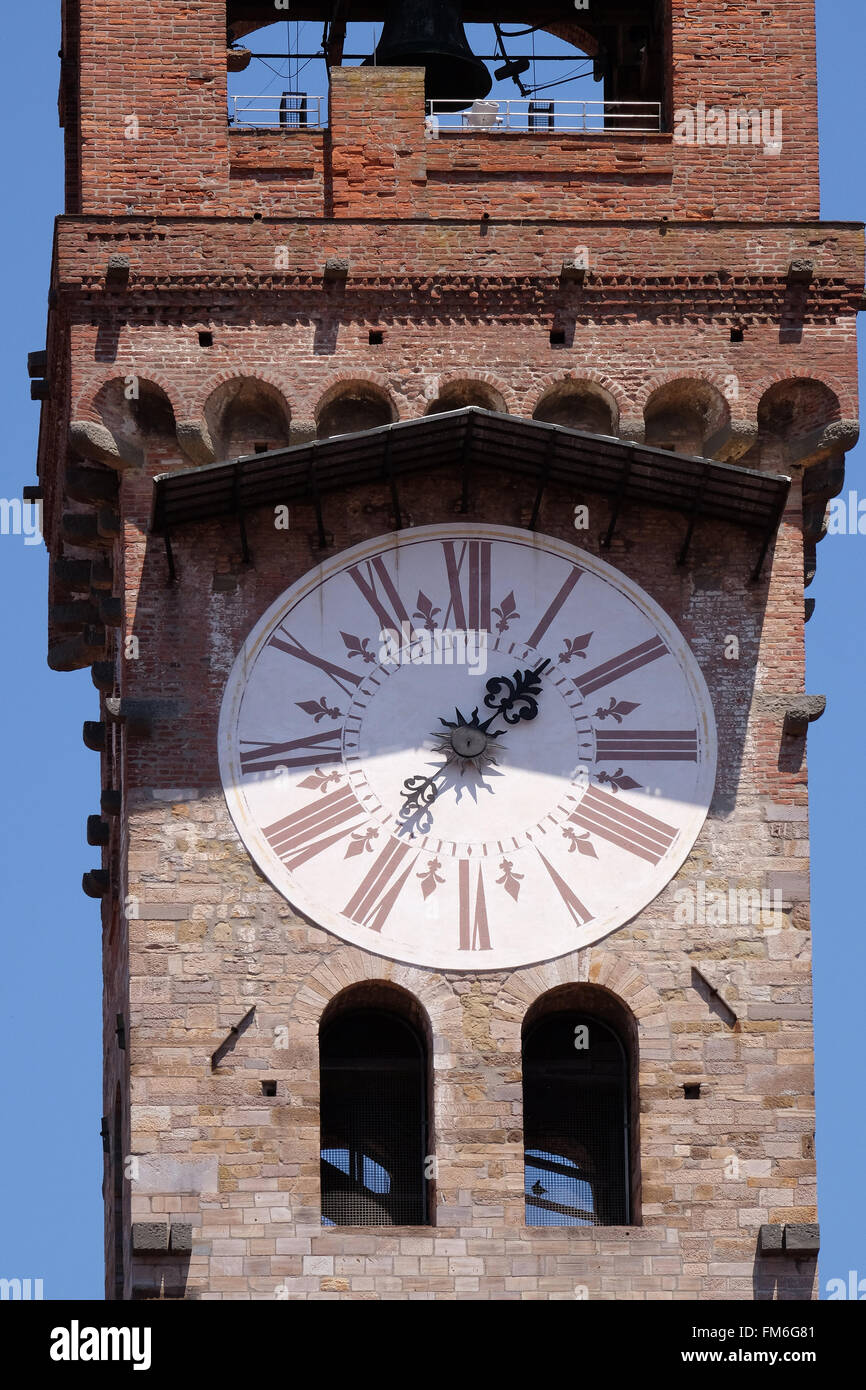 Torre Orologio, Stein-Glockenturm (Campanile) garniert mit Ziegelbogen und Uhr mit römischen Ziffern in Lucca, Italien Stockfoto