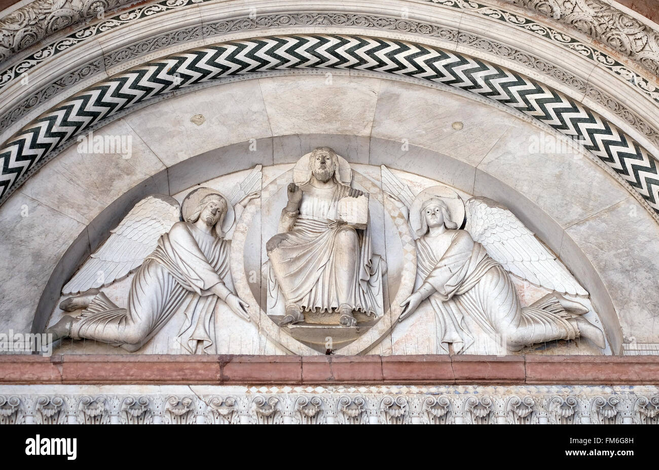Portal der Kathedrale von St. Martin in Lucca. Lünette zeigt den Erlöser in einer Mandorla, gehalten von zwei Engeln, Lucca, Italien Stockfoto