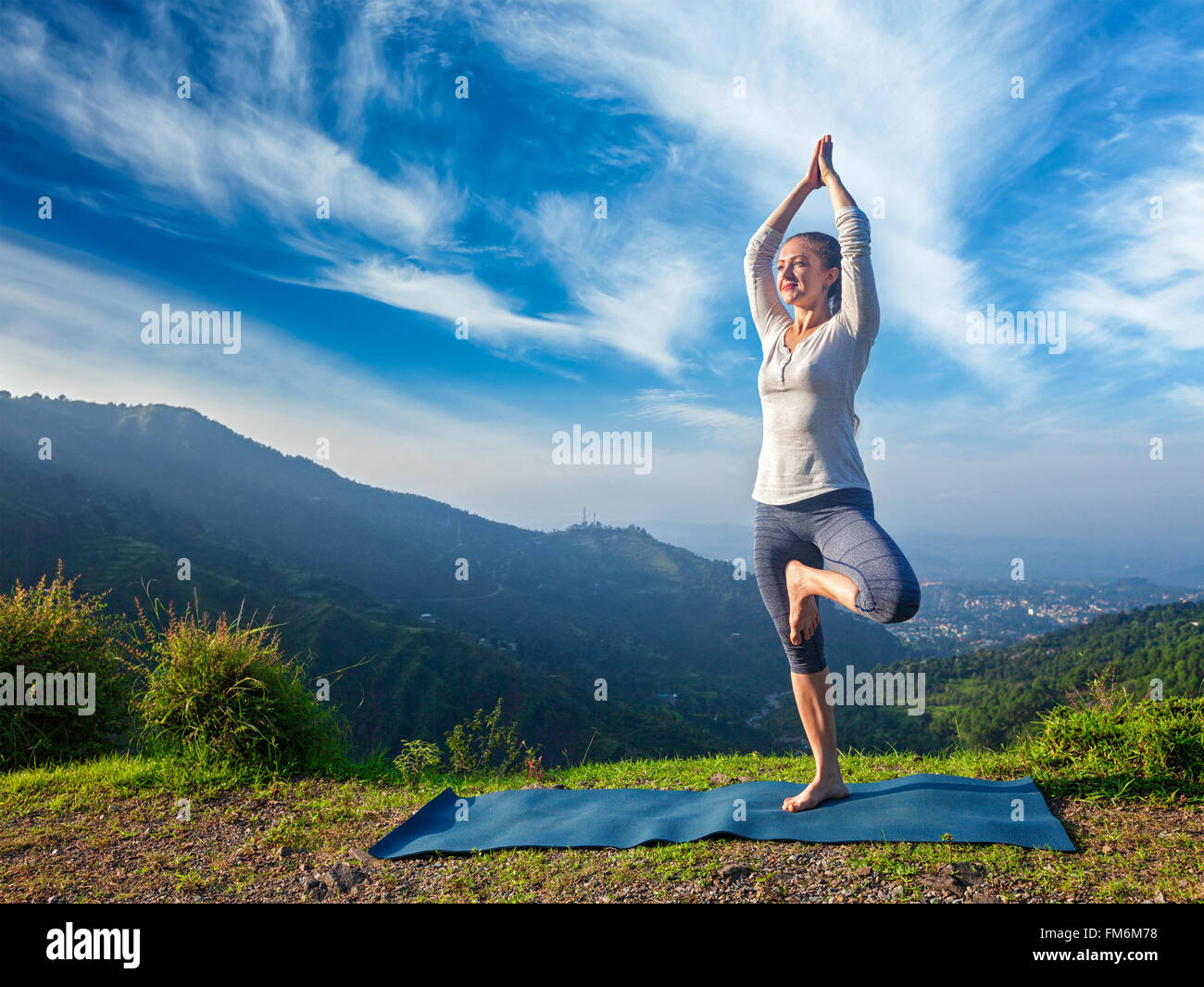 Frau im Yoga Vrikshasana-Baum stellen im freien Stockfoto