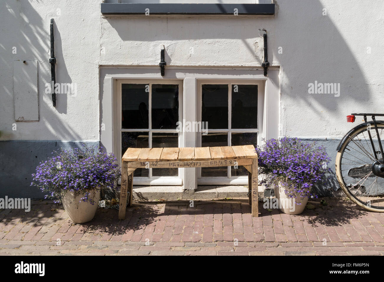 Niederländische Stadt Straßenszene mit Selfmade Holzbank, Haus Blumen in Töpfen und Rad Fahrrad vor Fenstern von alten in Ame Stockfoto