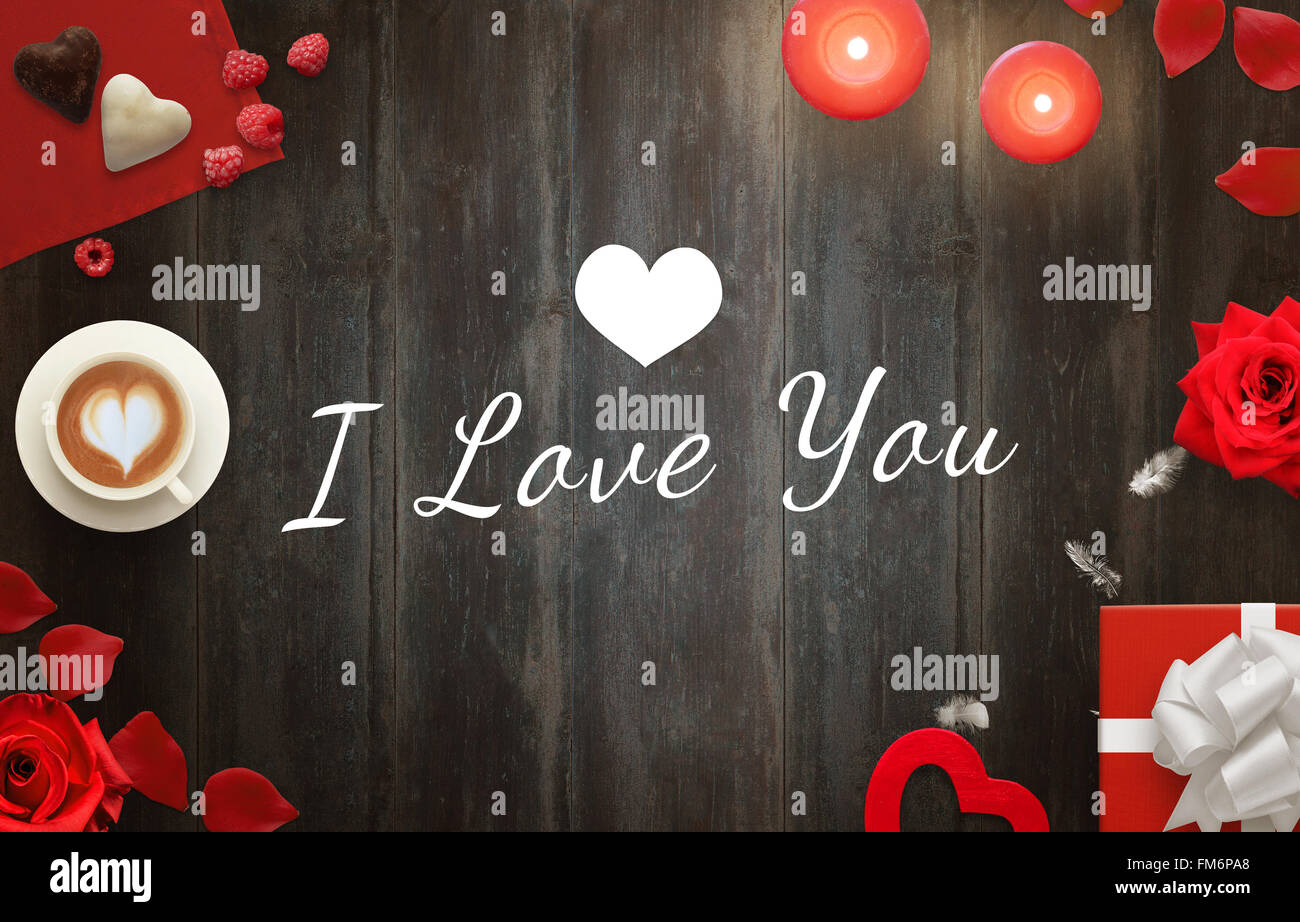 Ich liebe Ihre Nachricht mit Kaffee, Geschenke, Herzen, Kerzen, Rosen, Blütenblätter, Süßigkeiten auf Holztisch. Stockfoto