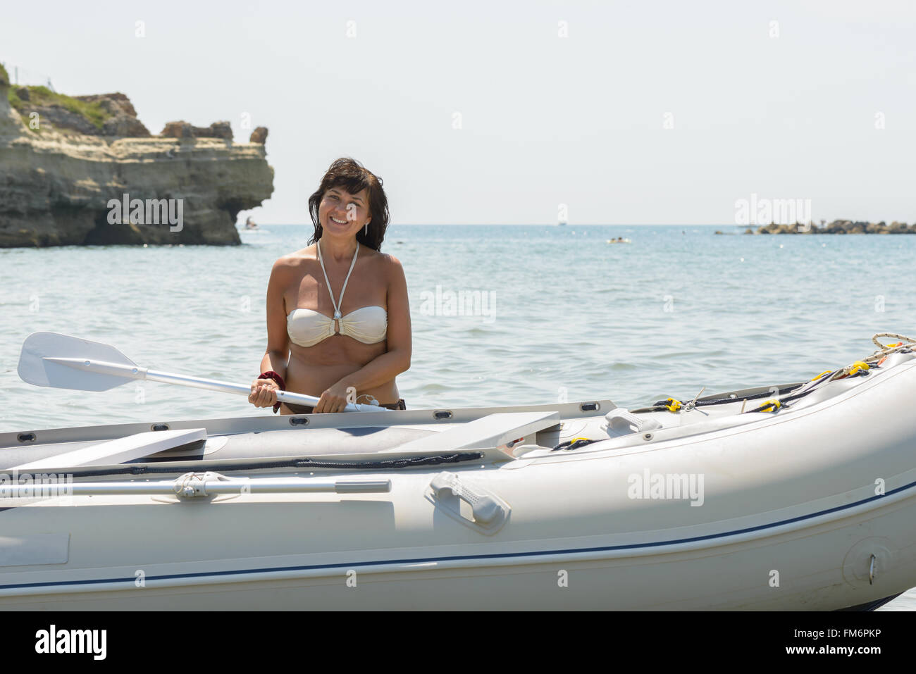 Mädchen im Meer lächelnd hinter einem Boot Stockfoto