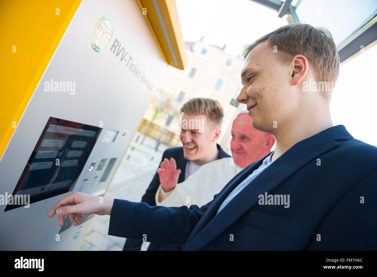 Regensburg, Deutschland. 8. März 2016. Deutsche hit Sänger Duo Kevin und Manuel steht neben einem Karton ausgeschnittenen Darstellung Papst Fancis vor ein Fahrkartenautomat an einer Bushaltestelle in Regensburg, Deutschland, 8. März 2016. Kevin und Manuel, ehemalige Mitglieder des Knabenchores der Regensburger Domspatzen haben ihren neuesten Hit mit dem Titel Papa Francesco freigegeben Sie und Zielen Sie darauf ab, den deutschen Musik-Charts zu erobern. Foto: Christina Sabrowsky/Dpa/Alamy Live News Stockfoto Regensburg, Deutschland. 8. März 2016. Deutsche hit Sänger Duo Kevin und Manuel steht neben einem Karton ausgeschnittenen Darstellung Papst Fancis vor ein Fahrkartenautomat an einer Bushaltestelle in Regensburg, Deutschland, 8. März 2016. Kevin und Manuel, ehemalige Mitglieder des Knabenchores der Regensburger Domspatzen haben ihren neuesten Hit mit dem Titel Papa Francesco freigegeben Sie und Zielen Sie darauf ab, den deutschen Musik-Charts zu erobern. Foto: Christina Sabrowsky/Dpa/Alamy Live News Stockfoto