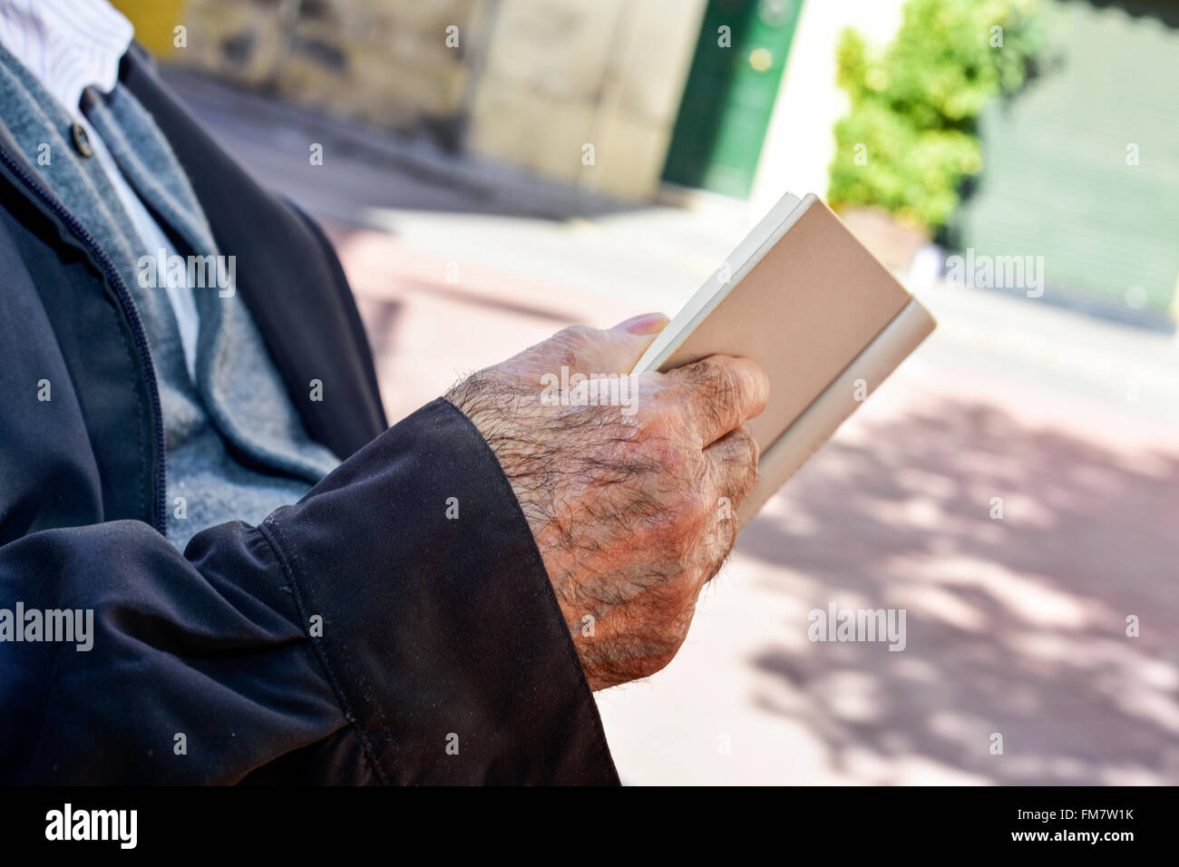 Nahaufnahme von einem alten kaukasischen Mann ein Buch im freien Stockfoto