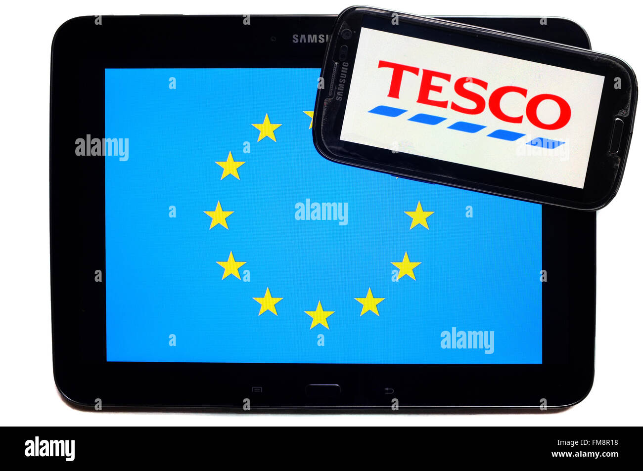Ein Smartphone mit dem Tesco Logo auf einem Tablet mit der EU-Flagge auf weißem Hintergrund fotografiert. Stockfoto