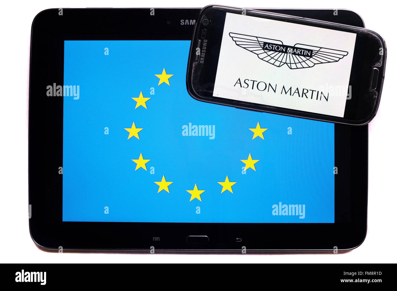 Ein Smartphone mit dem Aston Martin Logo auf einem Tablet mit der EU-Flagge auf weißem Hintergrund fotografiert. Stockfoto