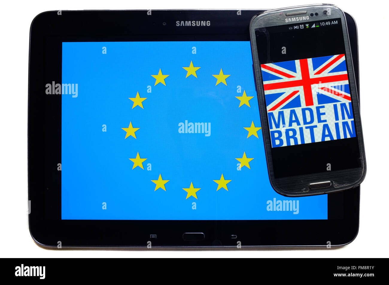 Ein Smartphone mit Made in Britain drauf auf ein Tablet mit der EU-Flagge auf weißem Hintergrund fotografiert. Stockfoto