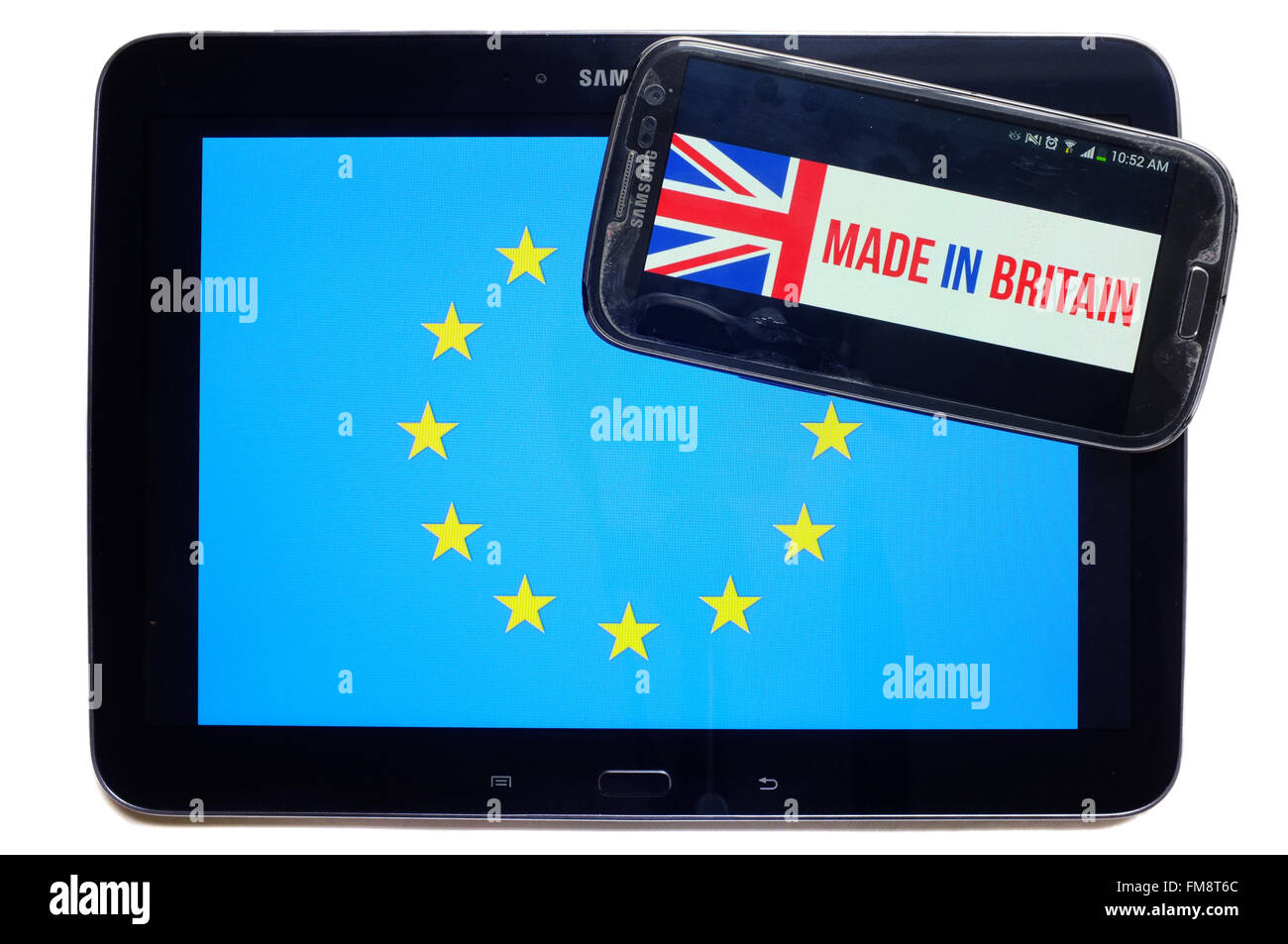Ein Smartphone mit Made in Britain drauf auf ein Tablet mit der EU-Flagge auf weißem Hintergrund fotografiert. Stockfoto