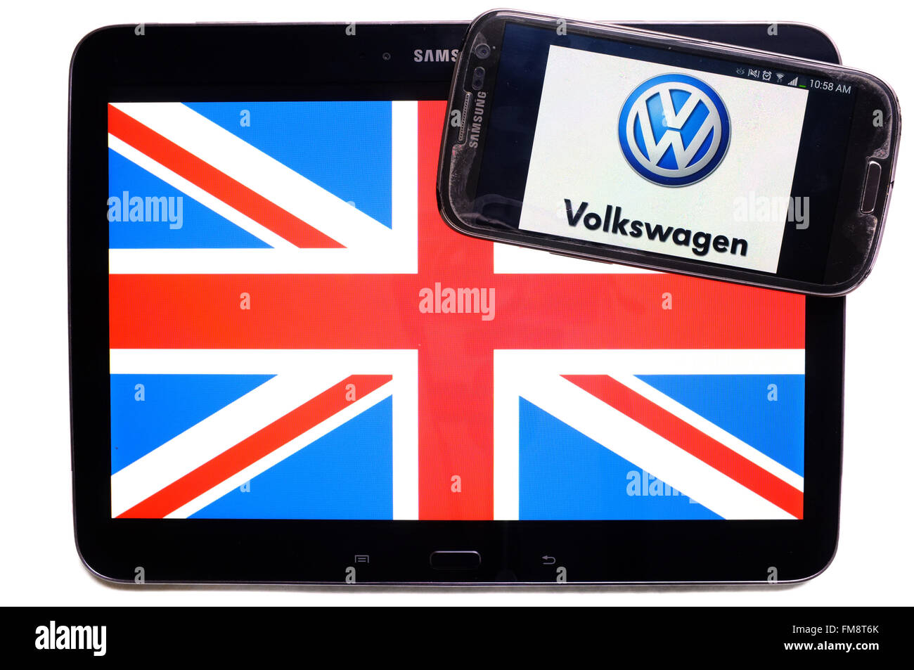 Der Union Jack auf einem Tablet und das Logo von Volkswagen auf einem Smartphone vor einem weißen Hintergrund. Stockfoto