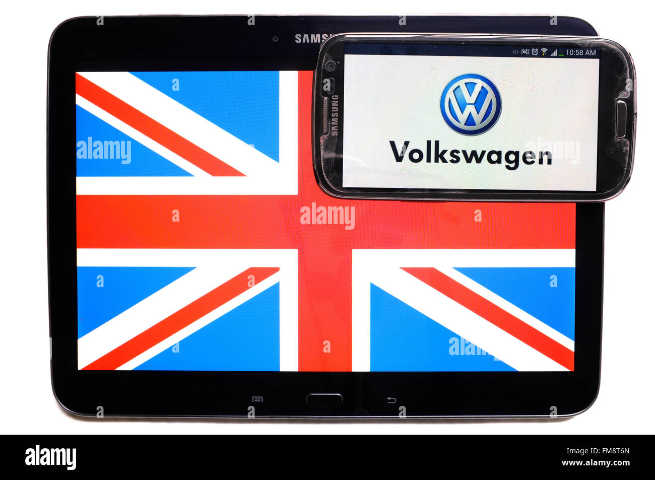Der Union Jack auf einem Tablet und das VW-Logo auf einem Smartphone vor einem weißen Hintergrund. Stockfoto