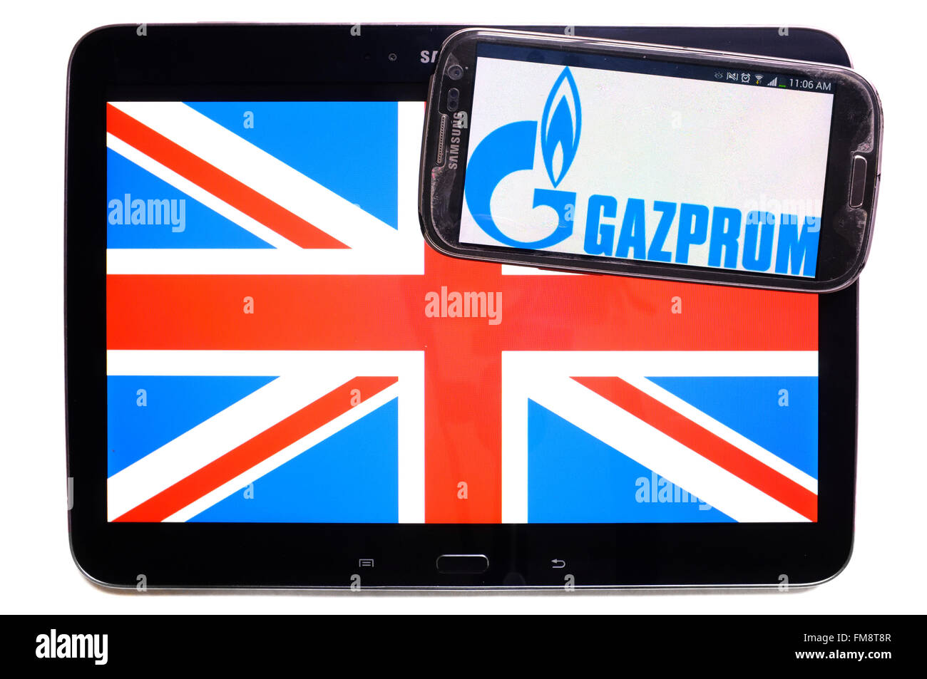 Der Union Jack auf einem Tablet und das Logo von Gazprom auf einem Smartphone vor einem weißen Hintergrund. Stockfoto