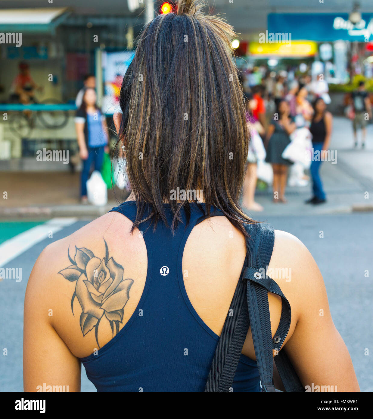 Schuss von Schulter Tattoo auf ein attraktives Mädchen Frau warten an der Ampel in Brisbane City Queensland Australien hautnah Stockfoto