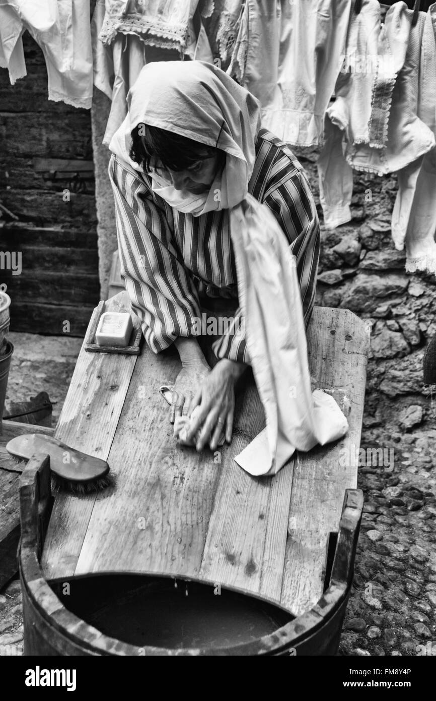 Riva del Garda, Italien - 26. Dezember 2015: Wäscherin wäscht Kleidung mit Wasser und Seife auf einem Holzbrett. Stockfoto