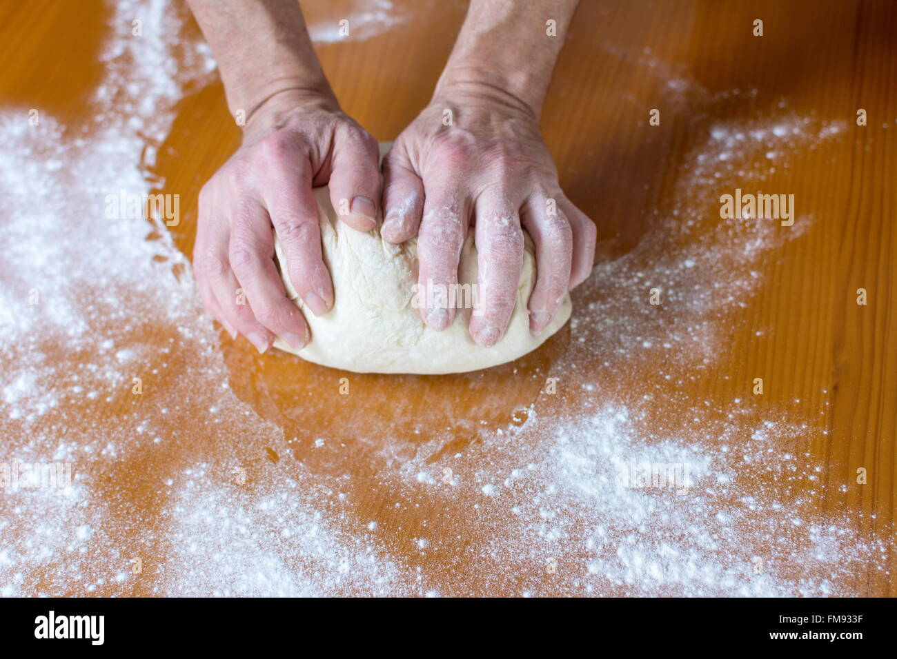 Hände eines männlichen Bäckers, die Herstellung von Brot auf dem Tisch Stockfoto