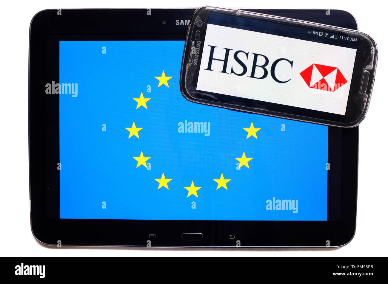 Ein Smartphone mit dem HSBC Logo auf einem Tablet mit der EU-Flagge auf weißem Hintergrund fotografiert. Stockfoto