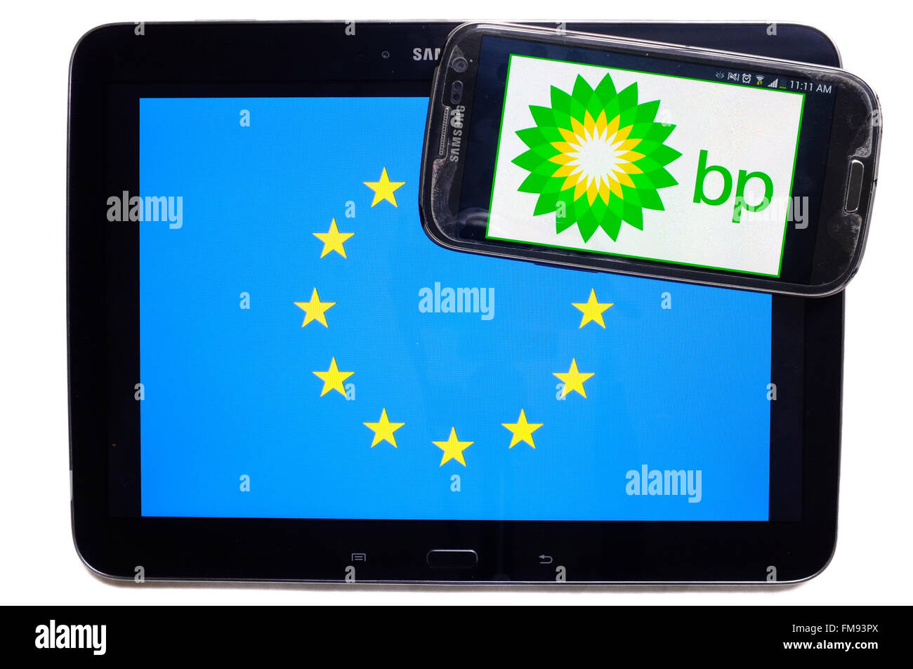 Ein Smartphone mit dem BP-Logo drauf auf einem Tablet mit der EU-Flagge auf weißem Hintergrund fotografiert. Stockfoto