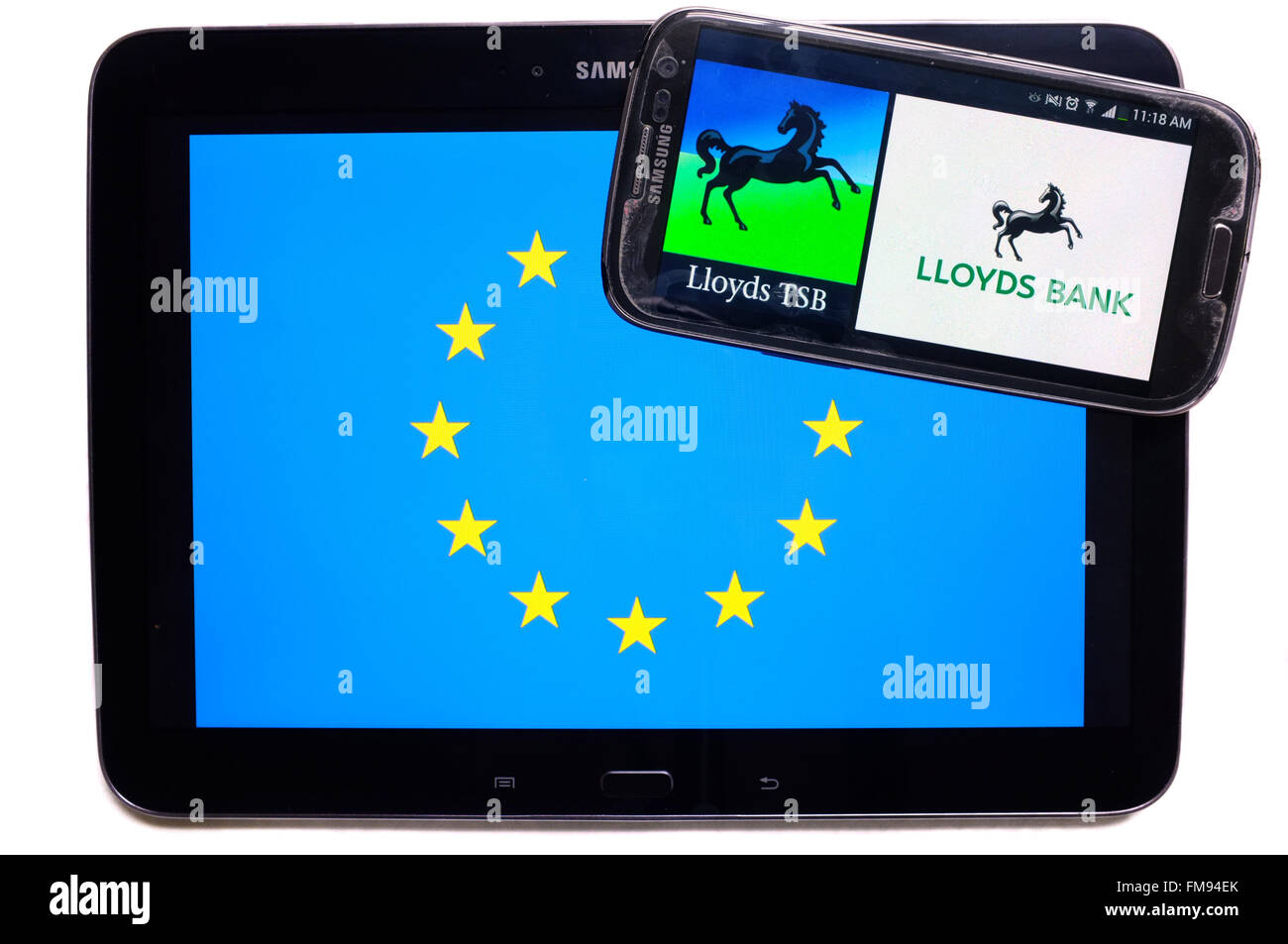 Ein Smartphone mit der Lloyds-Logo drauf auf einem Tablet mit der EU-Flagge auf weißem Hintergrund fotografiert. Stockfoto
