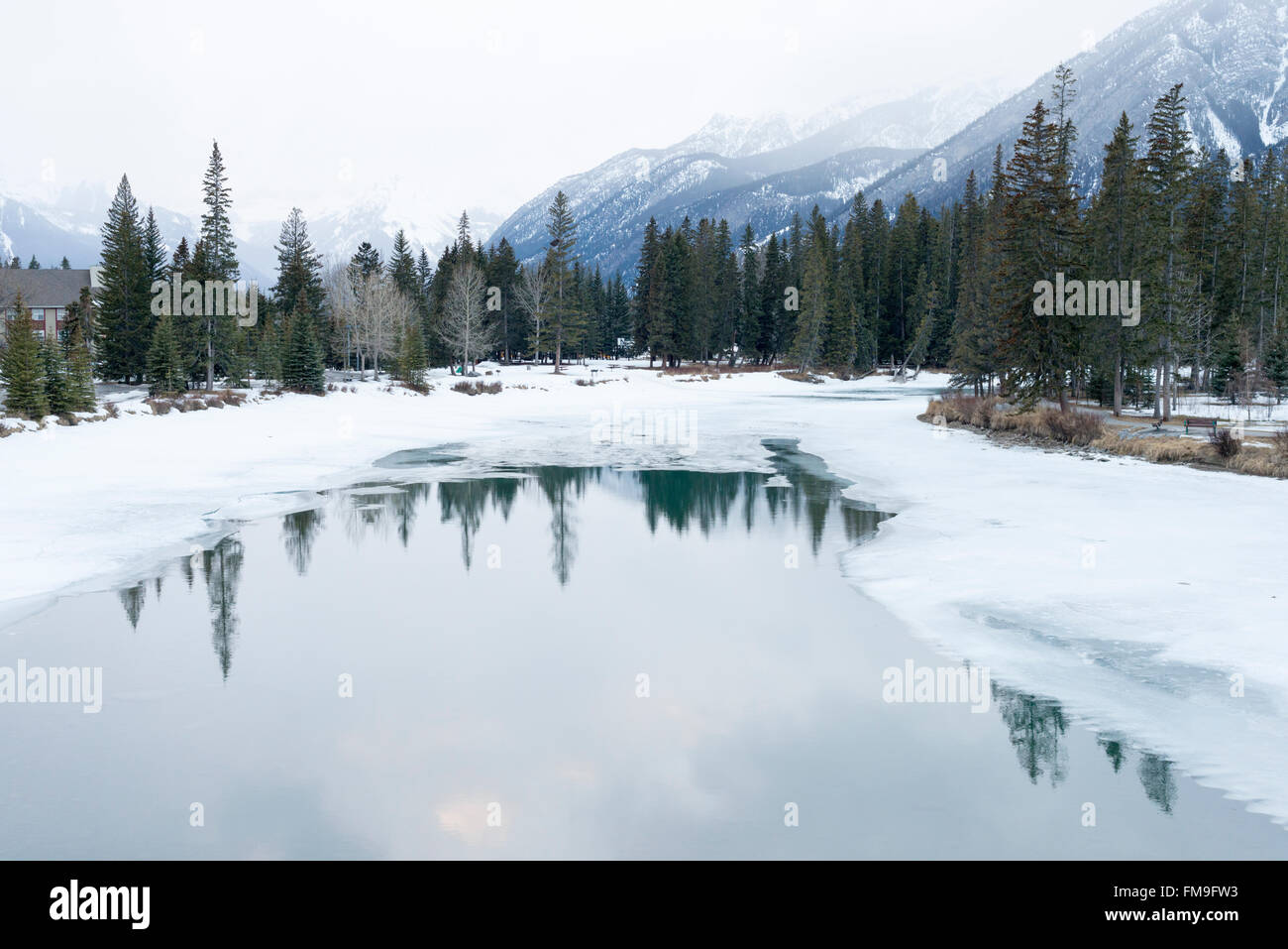 Eine Winterlandschaft im bewölkten Bedingungen am Bow River in den Rocky Mountains in Banff, Kanada im Winter mit Schnee Stockfoto