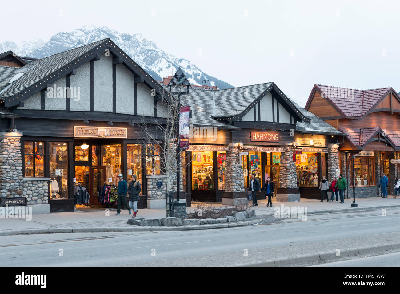 Geschäfte in Banff Avenue Banff Kanada bei Einbruch der Dunkelheit mit leuchtenden Lichtern. Stockfoto