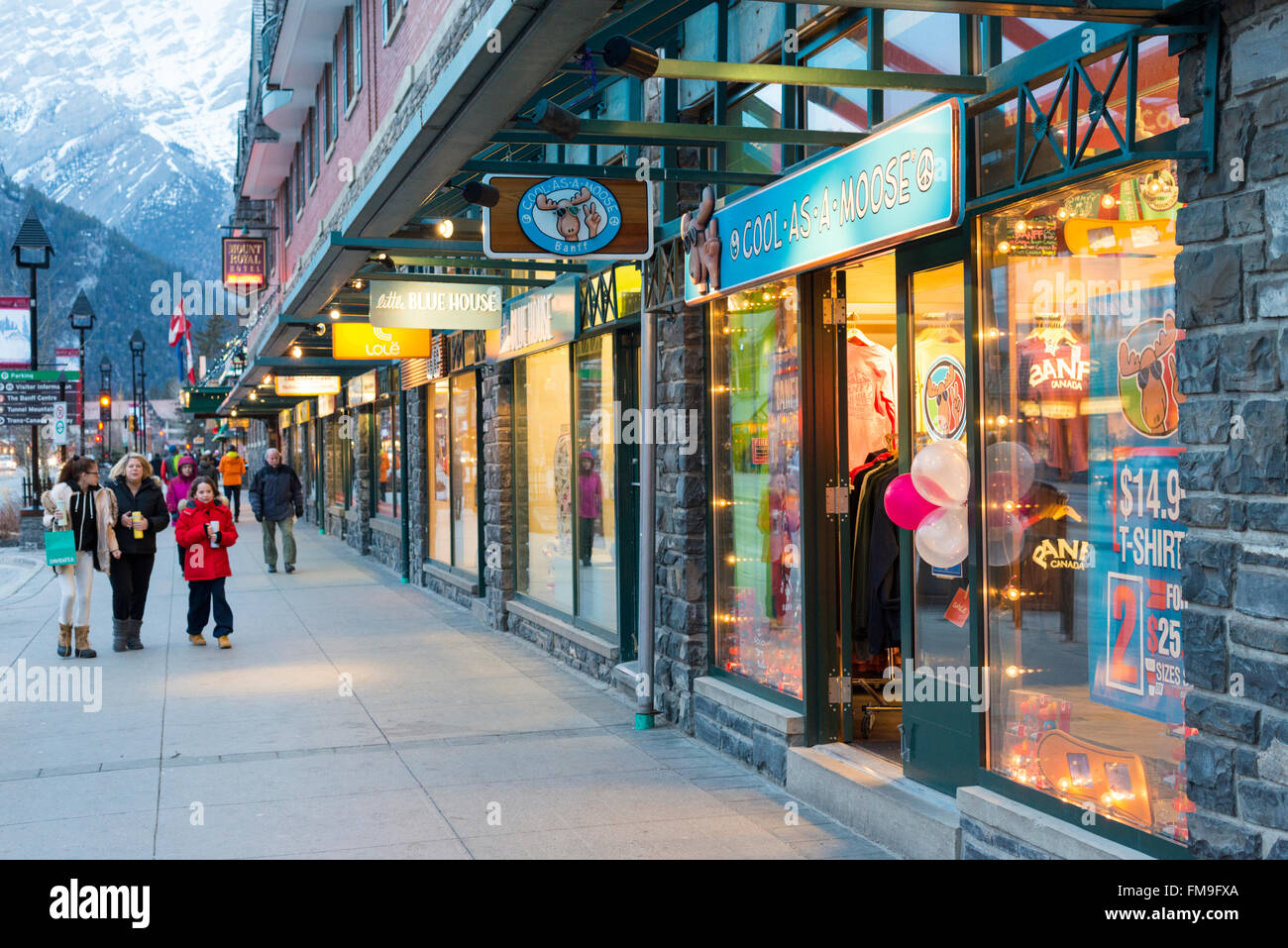 Geschäfte in Banff Avenue Banff Kanada bei Einbruch der Dunkelheit mit leuchtenden Lichtern. Stockfoto