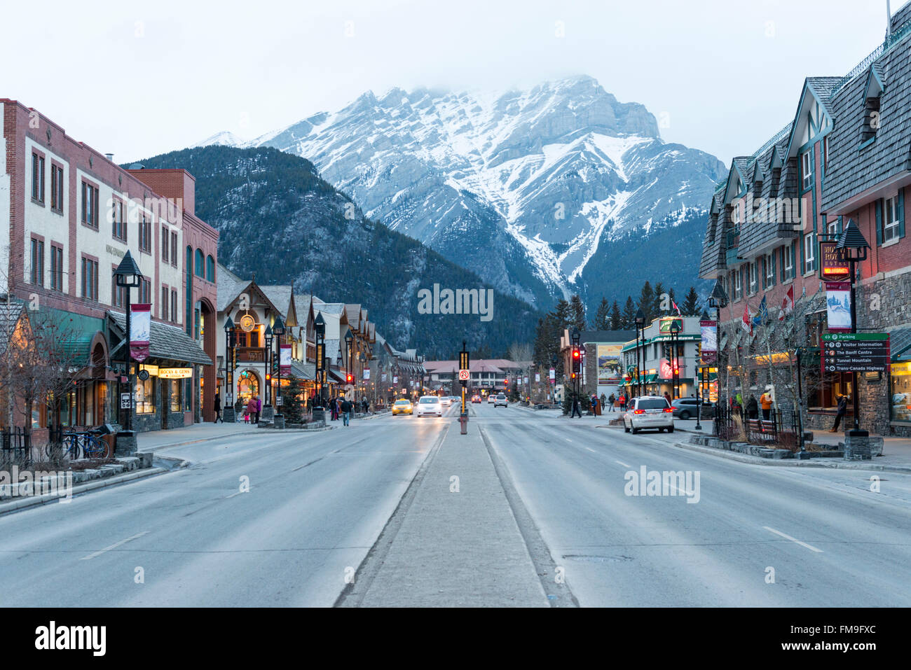 Geschäfte in Banff Avenue Banff Kanada bei Einbruch der Dunkelheit mit leuchtenden Lichtern. Stockfoto