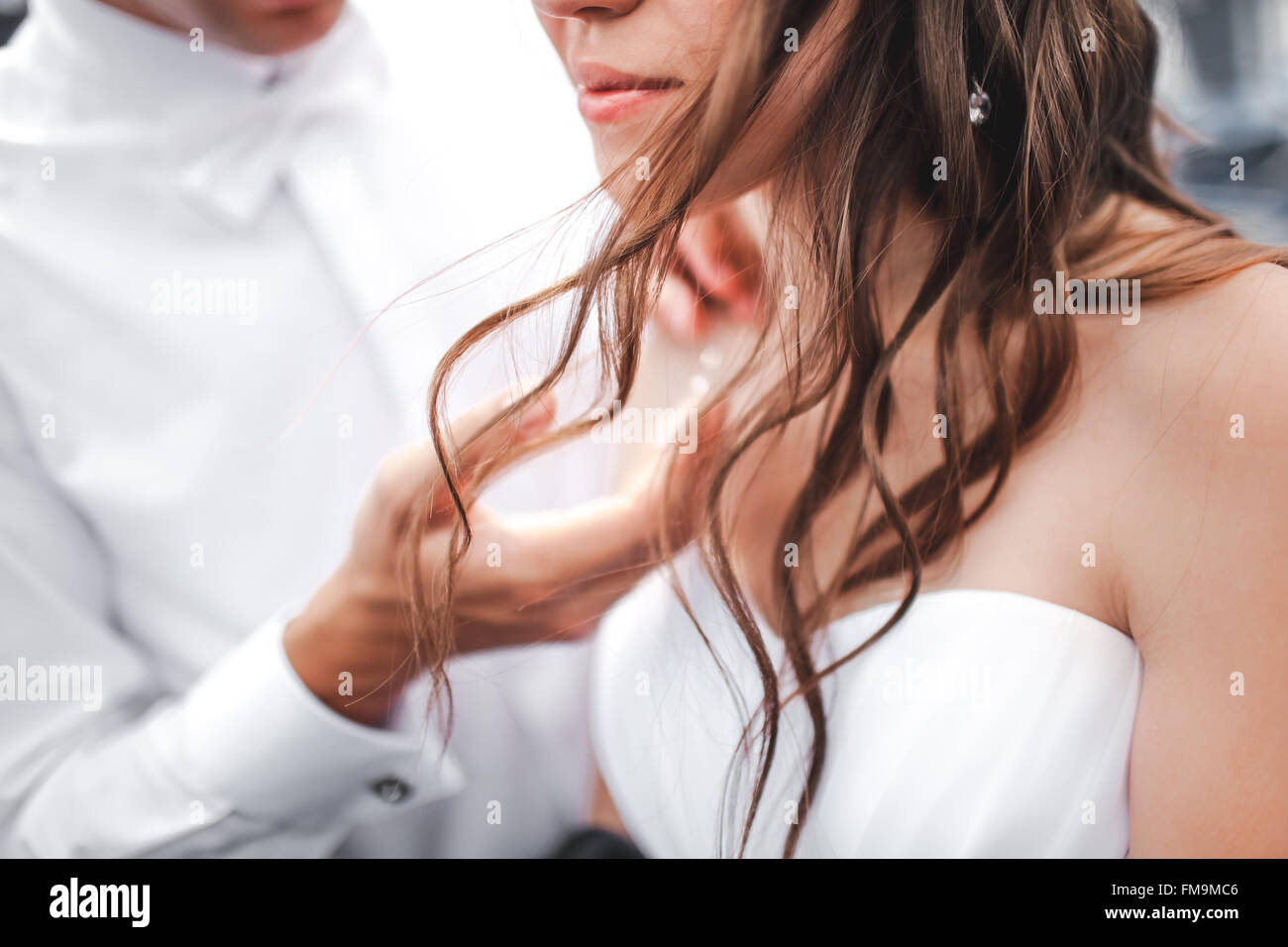 Der Bräutigam berührt sanft an die Braut, Nahaufnahme des fließenden Haaren. Stockfoto