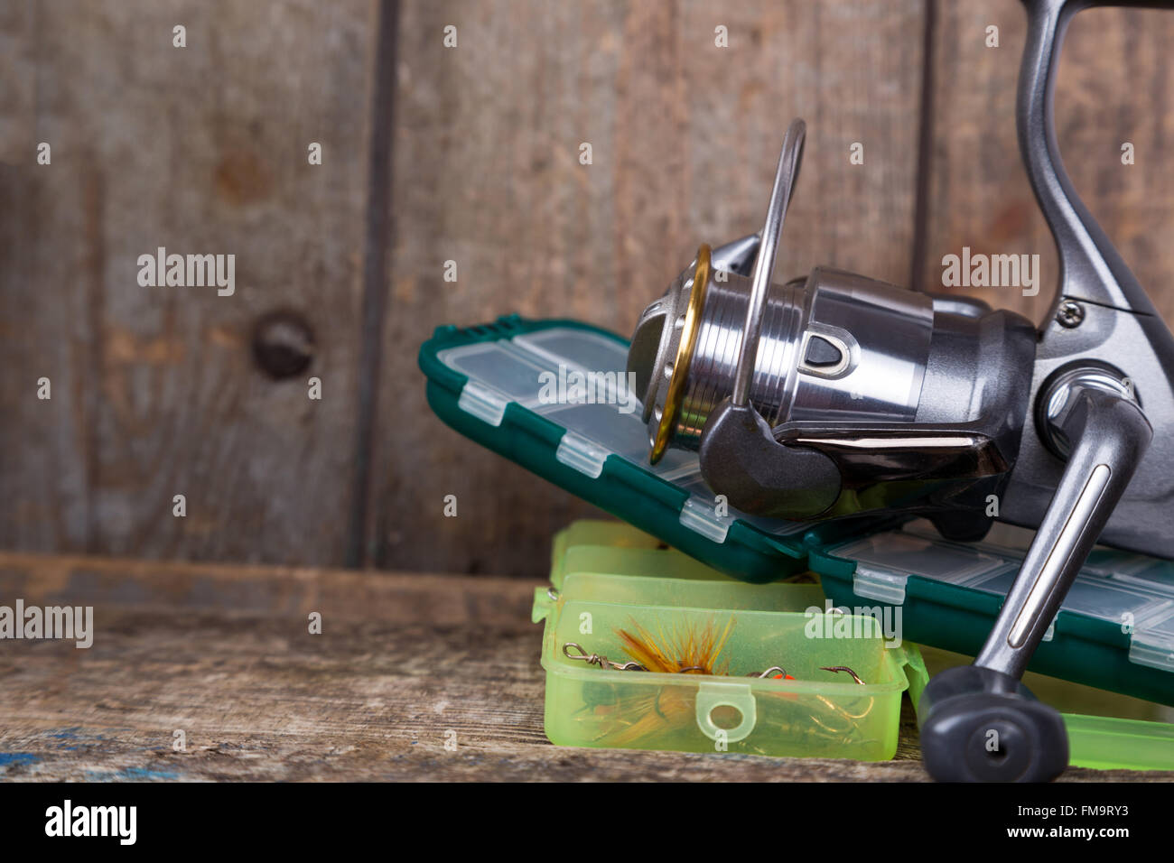 Angelgeräte, Köder und Köder in den Kästen auf Holzbalken Hintergrund für Outdoor-aktive Unternehmen Stockfoto