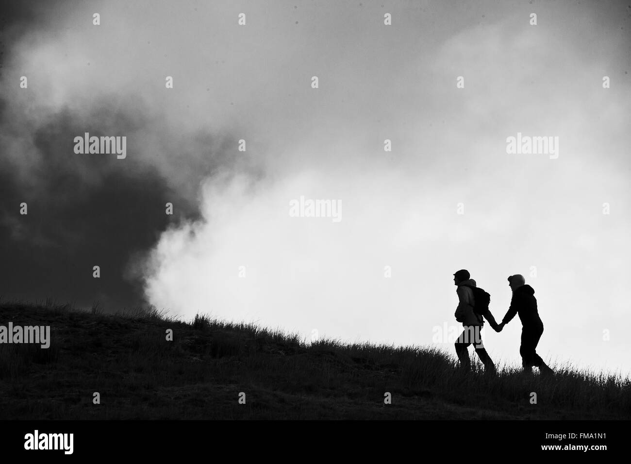 Liebhaber-paar zu Fuß hinauf Pen-y-Gent, Inglebrough auf Kalkstein Pflaster, Yorkshire Dales, England Stockfoto