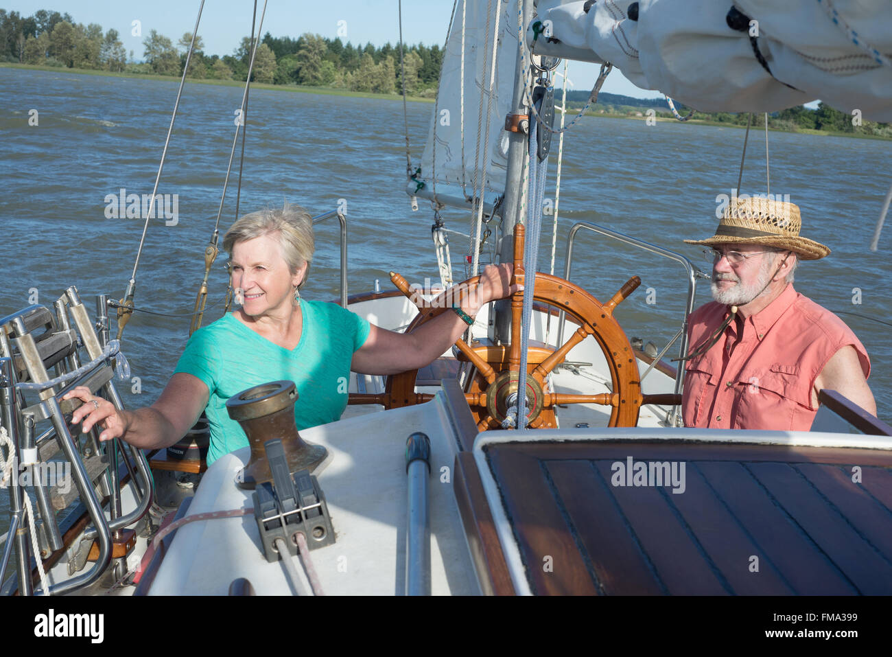 Ein glückliches senior Paar genießt Zeit zusammen Segeln auf einem See auf einem feinen Sommertag. Stockfoto