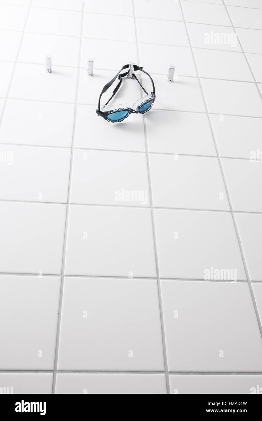 Schwimmbrille hängt an einem Haken auf einer Fliese Wand in einem Umkleideraum Stockfoto